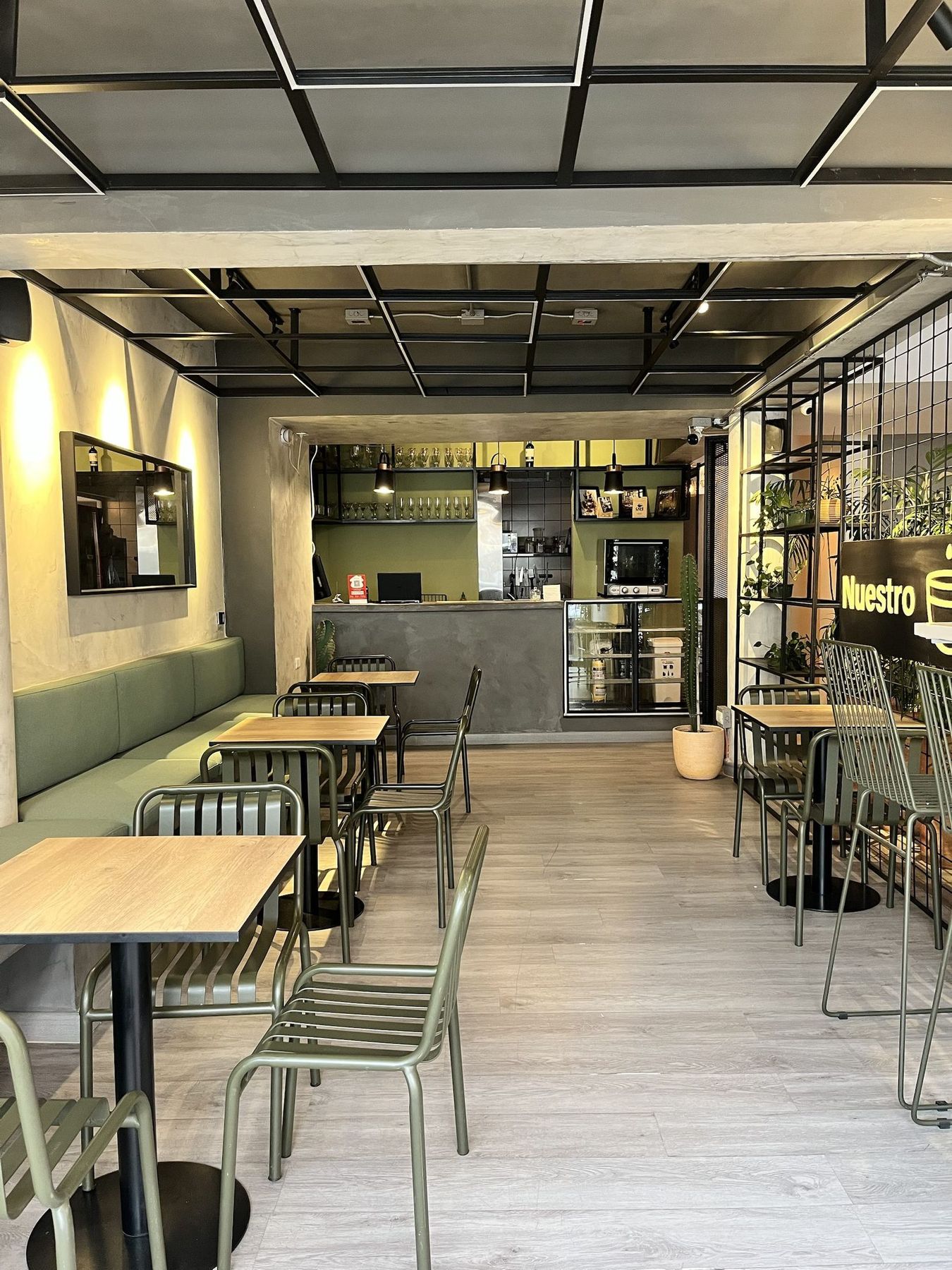 The ground-floor café, green banquettes and wood tables.