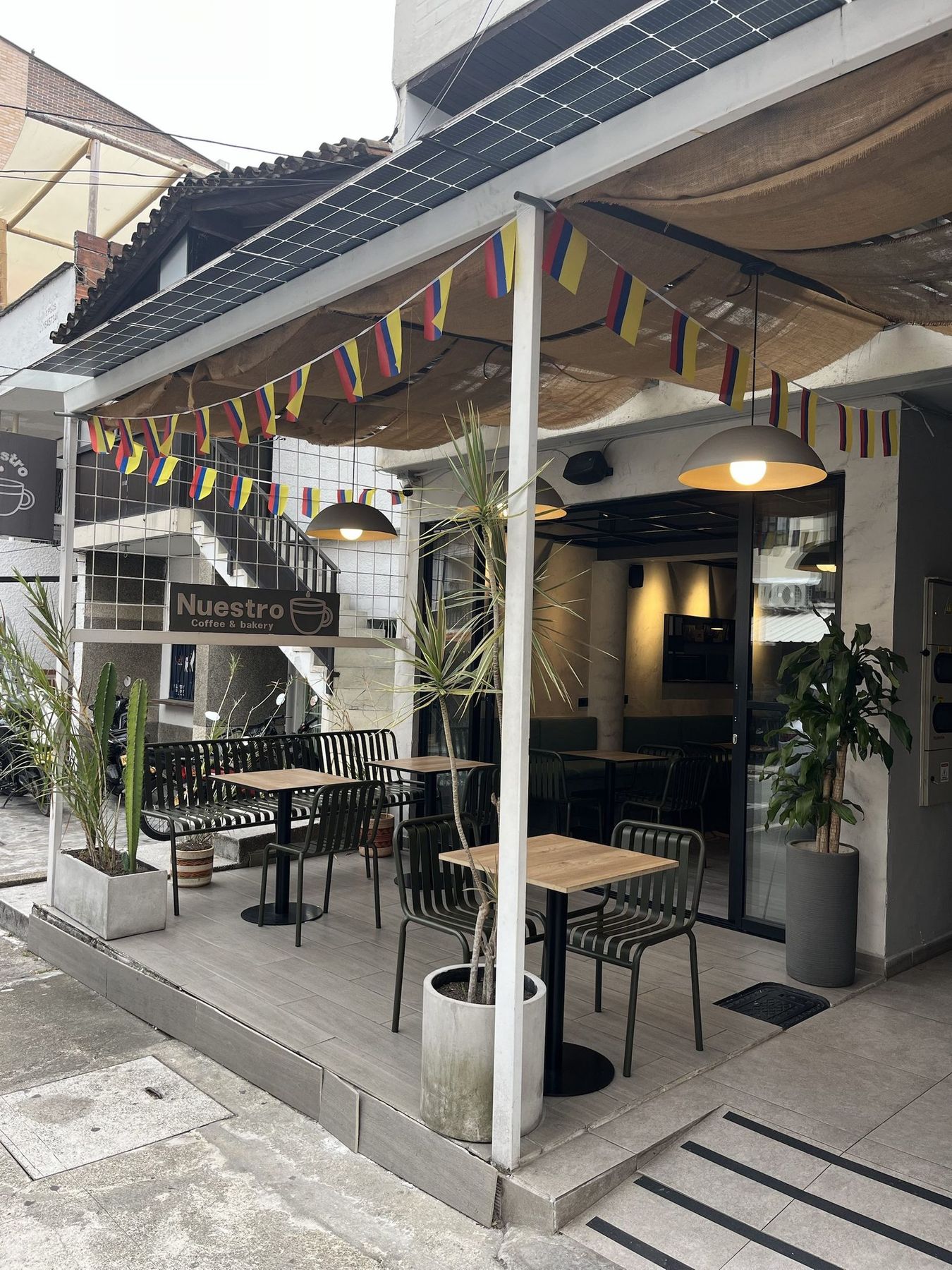 The café terrace from the street, bunting overhead.